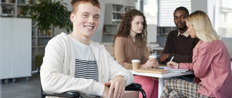 Estudante em cadeira de rodas na biblioteca