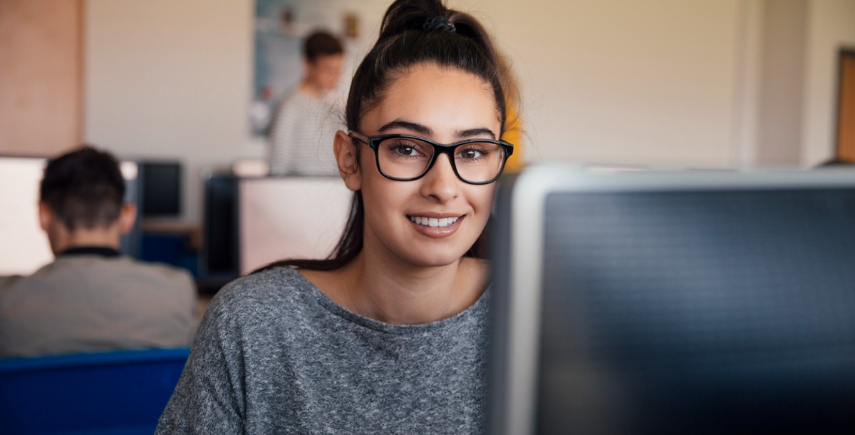 estudante universitária em frente ao seu computador